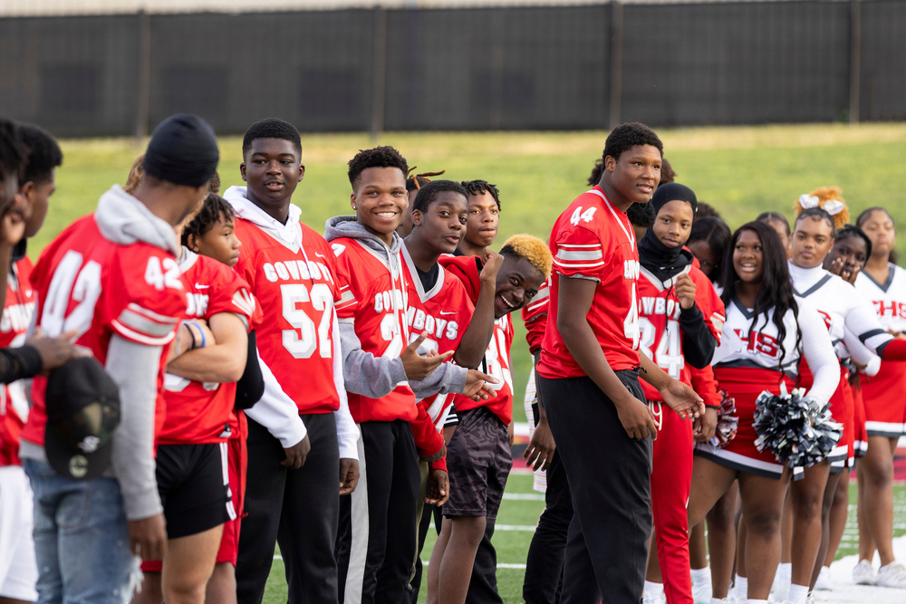 Chaney Cowboys high school football team flanked by Chaney High School cheerleaders.