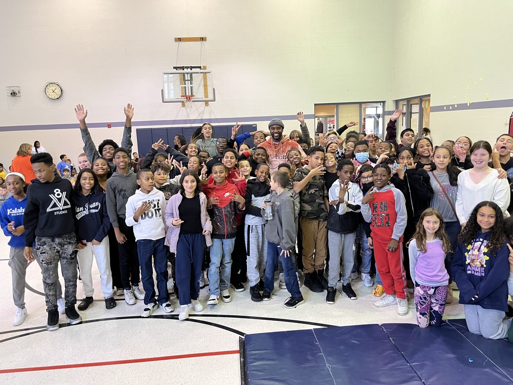Group photo of scholars with Otis Winston in a school gym